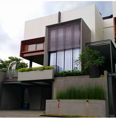 a modern house with plants on the balcony