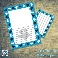 two dogs themed writing papers with blue and white paw prints on the paper, one is lined