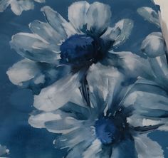 a blue and white painting with flowers on it's side, sitting on a table