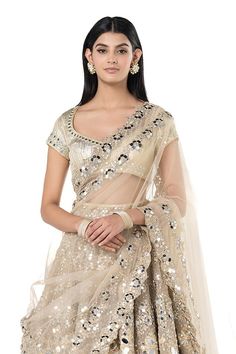 Beige-golden net lehenga with attached cancan, and floral pattern mirror embroidery. Comes with embroidered padded blouse and dupatta.
Components: 3
Pattern: Embroidered
Type Of Work: Mirror
Neckline: Leaf
Sleeve Type: Cap
Fabric: Net
Color: Beige
Other Details: 
Back cutout tassel tie-up blouse
Scalloped hem blouse
Fringed hem lehenga
Occasion: Wedding,Bride - Aza Fashions Gold Pre-draped Saree With Cutdana For Party, Gold Anarkali Pre-draped Saree With Sheer Dupatta, Diwali Pre-draped Saree With Sheer Dupatta And Beaded Detail, Festive Net Lehenga For Festivals, Gold Organza Traditional Wear For Navratri, Gold Net Anarkali Set With Sheer Dupatta, Gold Sharara With Zari Work For Reception, Gold Gown With Mirror Work In Traditional Drape, Gold Organza Anarkali Set For Navratri