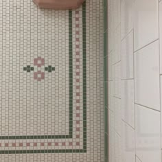 a bathroom with a pink toilet and tiled wall next to a urinal in the corner