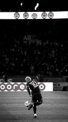 a soccer player is kicking the ball in front of an empty stadium full of people