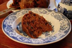 a piece of cake sitting on top of a blue and white plate next to a cup