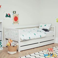 a child's bedroom with a white bed and toy animals on the wall next to it