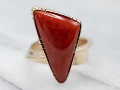 Bold color, funky design, and twisting tapered shoulders make this vintage ring truly stand out! Crafted of 14-karat yellow gold this vintage mounting has been inlaid with a salmon-hued coral, creating a wonderful color combination that is irresistible to ignore! Metal: 14K Yellow Gold Gem: Coral Gem Measurements: 21.4 x 11.2 mm, Triangle Ring Size: 7.50Marks: "KIRK 14K" Stamped on the inside band Triangle Ring, Chunky Ring, Coral Ring, Engagement Ring Diamond Cut, Funky Design, Coral And Gold, Chunky Rings, Cabochon Ring, Put A Ring On It