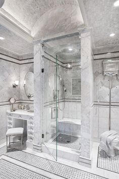 a white bathroom with marble walls and floors