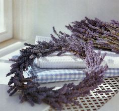 some lavender flowers are laying on top of white towels and blue checkered napkins