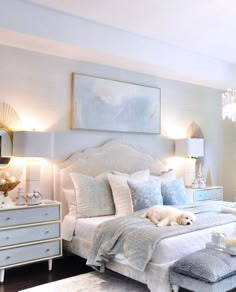 a white bed sitting in a bedroom next to two lamps