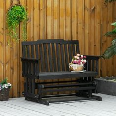 a wooden bench sitting in front of a wooden fence