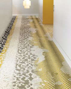 a hallway with yellow and gray carpeting next to white walls