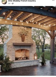 an outdoor fireplace with string lights and potted plants