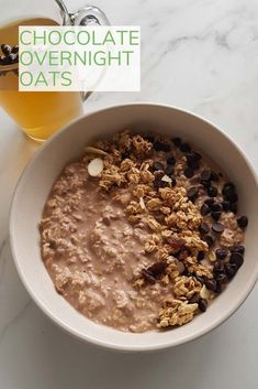 a bowl of oatmeal with chocolate chips and nuts in it next to a glass of beer