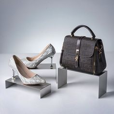 two women's shoes and a handbag on display