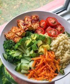 a white bowl filled with rice, broccoli, carrots and tofu