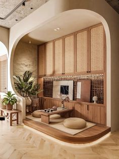 a living room filled with lots of furniture and plants on top of a wooden floor