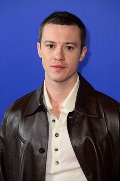 a man wearing a leather jacket and white shirt