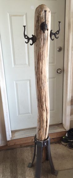 a large piece of driftwood is on display in front of a door with hooks