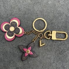 Add A Touch Of Luxury To Your Daily Routine With This Authentic Louis Vuitton Keychain. The Portocle Design Features A Beautiful Blooming Flower In Pink And Gold, Perfect For Adding A Pop Of Color To Your Keys Or Bag. Made Of High-Quality Metal, This Keychain Is Durable And Long-Lasting, Ensuring You Can Rely On It For Years To Come. The Brand's Signature Designer Logo Is Prominently Displayed On The Piece, Adding To Its Appeal And Authenticity. Ideal For Women Who Love To Accessorize, This Keychain Is A Must-Have For Any Fashion-Forward Individual. Things To Note: * Light Scratches And Tarnishing * Box And Dust Bag Not Included * 100% Authentic Louis Vuitton Keychain, Louis Vuitton Pink, Painted Bags, Designer Logo, Louis Vuitton Accessories, Blooming Flowers, Key Card Holder, Authentic Louis Vuitton, Daily Routine