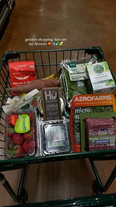 a shopping cart filled with groceries sitting on top of a floor next to a table