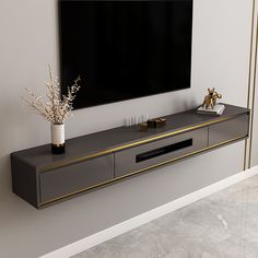 an entertainment center with a large flat screen tv mounted on the wall and gold trimmings