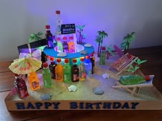 a birthday cake made to look like a beach scene with alcohol bottles and umbrellas