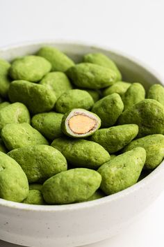 a white bowl filled with green colored rocks