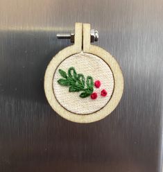 an embroidered ornament hanging on the side of a stainless steel refrigerator freezer