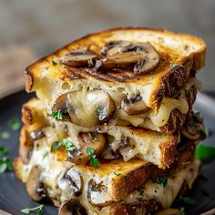 two grilled sandwiches stacked on top of each other, topped with mushrooms and parsley