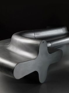 a metal object sitting on top of a white table next to a black wall and floor