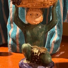 a ceramic figurine holding a basket on his head