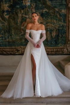 a woman in a white wedding dress with a thigh high slit