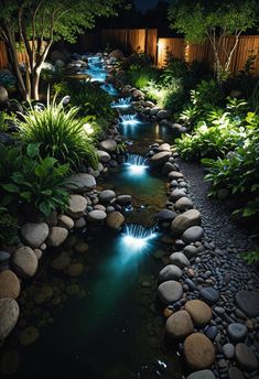 a garden with rocks and water features lights in the pond, along with other plants