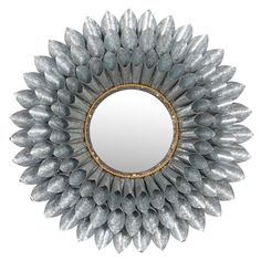 a round mirror that is made out of metal and has silver leaves on the rim