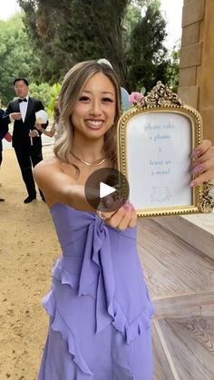 a woman in a purple dress holding up a sign