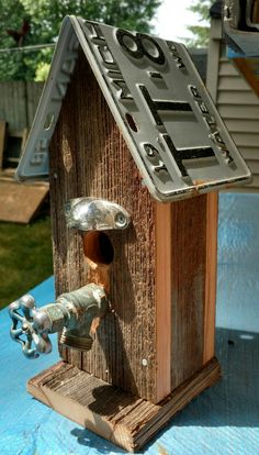 a wooden birdhouse with a metal door and window on top of a blue table