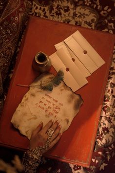 a woman's hand on top of an old piece of paper