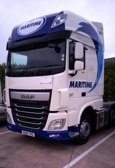 a white and blue truck parked in a parking lot