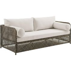 a wicker couch with white pillows on it's back and side cushions in the front