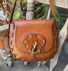 Medium size vintage leather hippie boho festival bag with a wooden toggle for closure..this is a good  size bag...I saddle soaped this bag to refreshen the leather.... Measurements are: 8 1/2 inches tall, 9 inches across, gusset measures 2 1/2 inches and the shoulder strap drop is 15 inchesthis bag is in good condition, no visible stains. 70s Bags, Spring Purses, Boho Crossbody Bag, Macrame Purse, Diy Leather Bag, Bohemian Bags, Spring Bags, Leather Flower, Hippie Bags