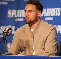 a man sitting in front of a microphone at a press conference