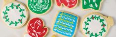 decorated cookies are arranged in the shape of ovals and ovals on a white surface