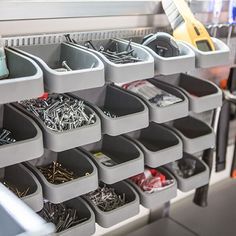 several bins with various types of screws and nails in them on a shelf