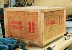 a large wooden box sitting on top of a table next to other boxes and tools