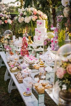 a table topped with lots of cakes and cupcakes