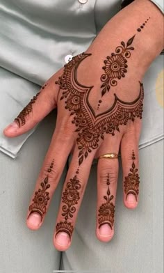 a woman's hand with henna tattoos on it, and her hands in the middle