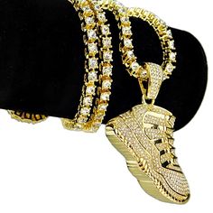 One-row chain tennis necklace with dazzling micro pave shoe pendant. Bling chain measures 24" long x 6MM wide. High quality gold finish over base metal. Stylish box clasp to lock your tennis chain. Blinged out shoe 1-row pendant chain has some weight to it at 80 grams. Features a multitude of round-cut stones for a stunning piece that shines bright. Shoe pendant is 1.83" wide x 1.15" tall. 100% FREE SHIPPING in USA. Order now! Noise Rings, Bright Shoe, Shoe Chain, Chain Locket, Shoe Pendant, Tennis Chain, Gold Shoes, Box Clasp, Tennis Necklace