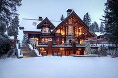 a large log home in the snow at night