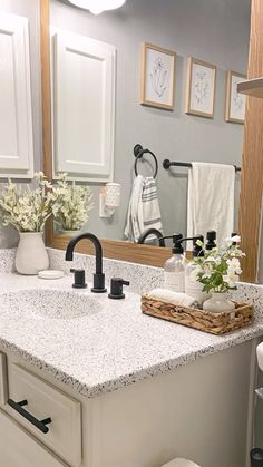 a bathroom with white cabinets and marble counter tops