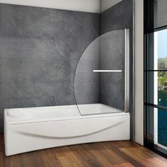 a bathroom with a large window and a bathtub next to a wall that has a circular mirror on it