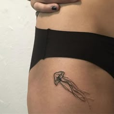 a woman's stomach with a small tattoo on the side of her belly, which has a line drawing of a human hand